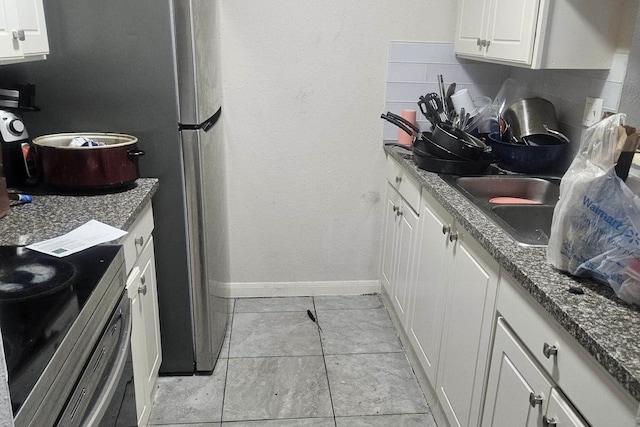 kitchen with white cabinetry, light tile patterned floors, and decorative backsplash