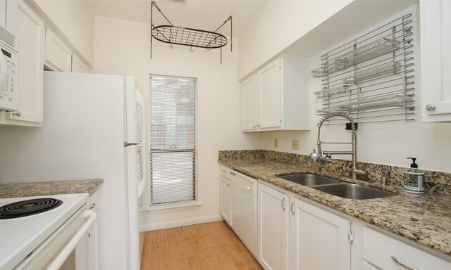 kitchen with white appliances, white cabinets, sink, light hardwood / wood-style flooring, and light stone counters