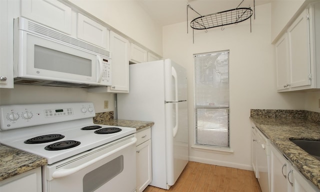 kitchen with white cabinetry, light hardwood / wood-style flooring, stone countertops, and white appliances