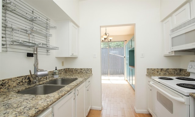 kitchen with light stone countertops, white cabinets, a chandelier, and white appliances