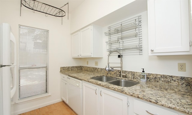 kitchen with white appliances, white cabinets, sink, light hardwood / wood-style floors, and light stone counters