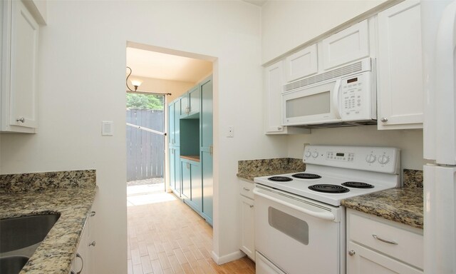 kitchen featuring stone counters, white appliances, white cabinetry, and sink