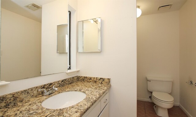 bathroom featuring toilet, vanity, and tile patterned floors