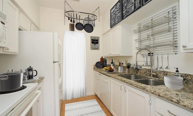 kitchen with light stone countertops, white appliances, light hardwood / wood-style flooring, and white cabinetry