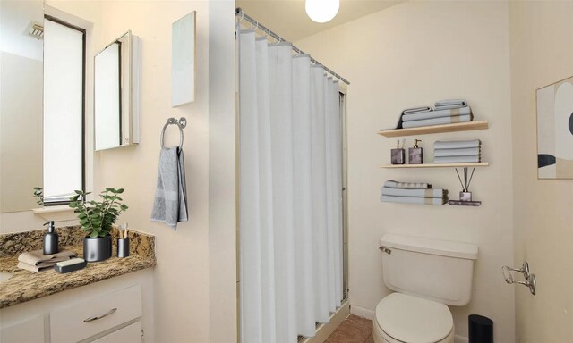 bathroom featuring a shower with shower curtain, vanity, and toilet