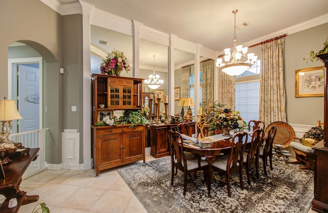 tiled dining room featuring crown molding and a chandelier