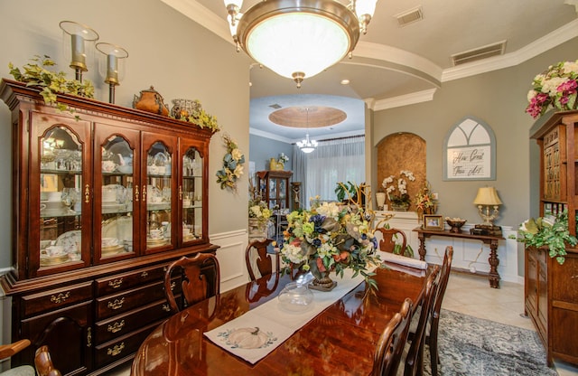 dining room with an inviting chandelier, light tile patterned floors, and ornamental molding