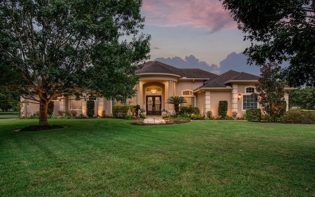 view of front of home featuring a lawn and french doors