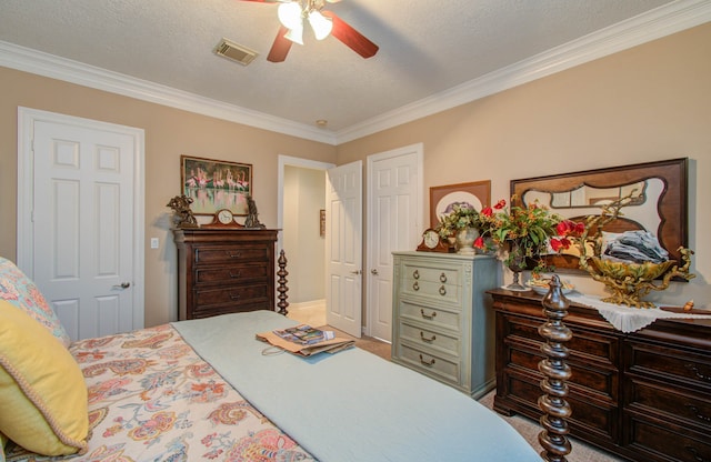 bedroom with ceiling fan, crown molding, and a textured ceiling