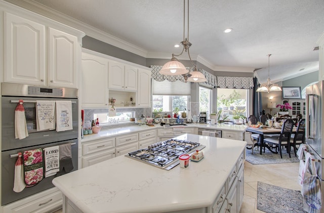 kitchen with a center island, white cabinets, crown molding, hanging light fixtures, and stainless steel appliances