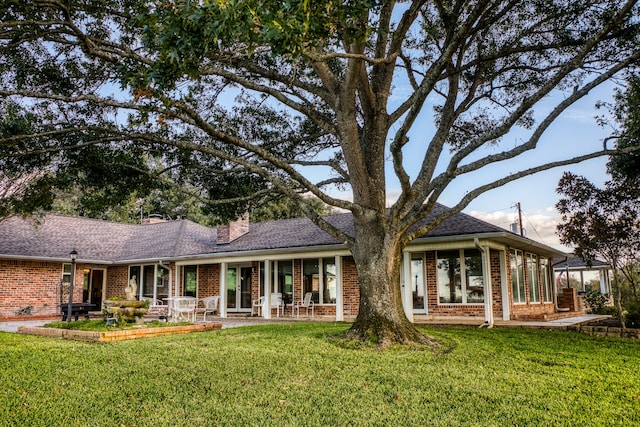 rear view of property featuring a lawn