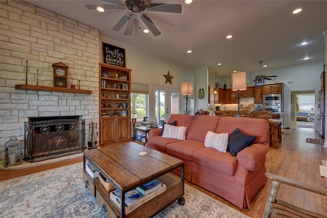 living room with ceiling fan, light hardwood / wood-style flooring, and a fireplace