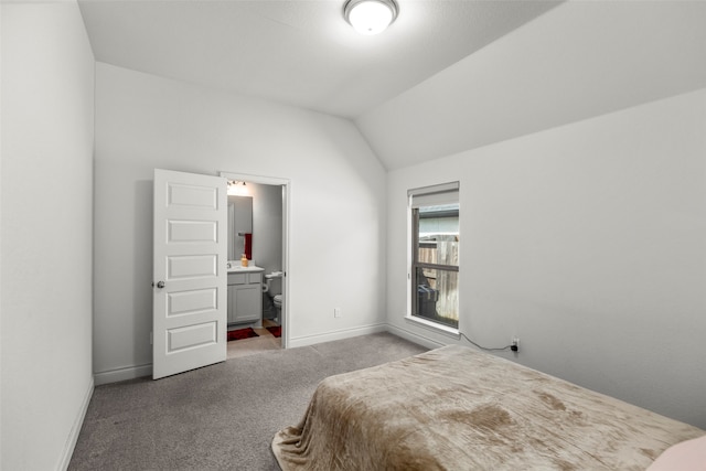 bedroom with connected bathroom, vaulted ceiling, and light colored carpet