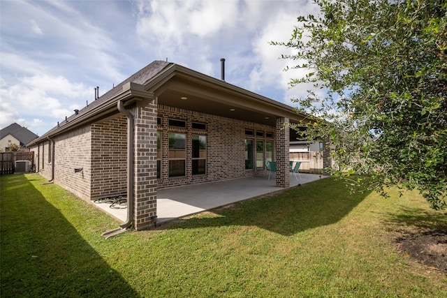 rear view of house with a patio and a lawn