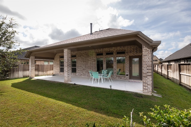 back of house featuring a patio and a lawn