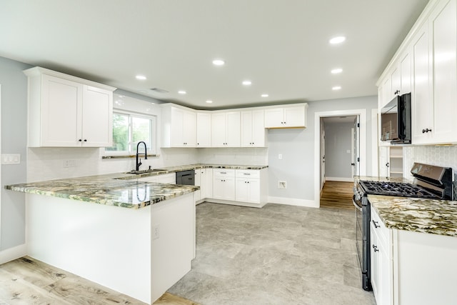 kitchen featuring white cabinets, stainless steel gas range oven, stone counters, and light hardwood / wood-style flooring