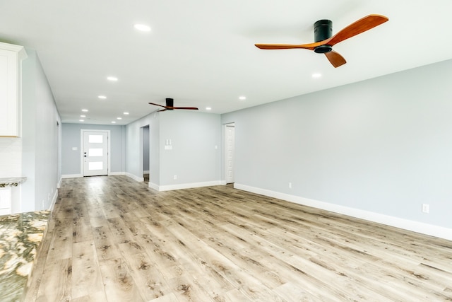 unfurnished living room featuring light hardwood / wood-style flooring and ceiling fan