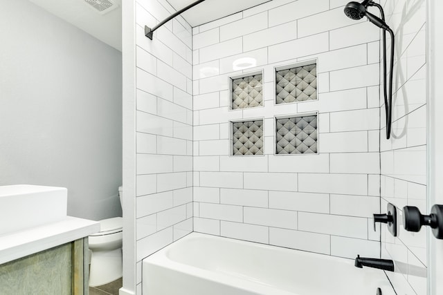 full bathroom with tiled shower / bath combo, vanity, and toilet