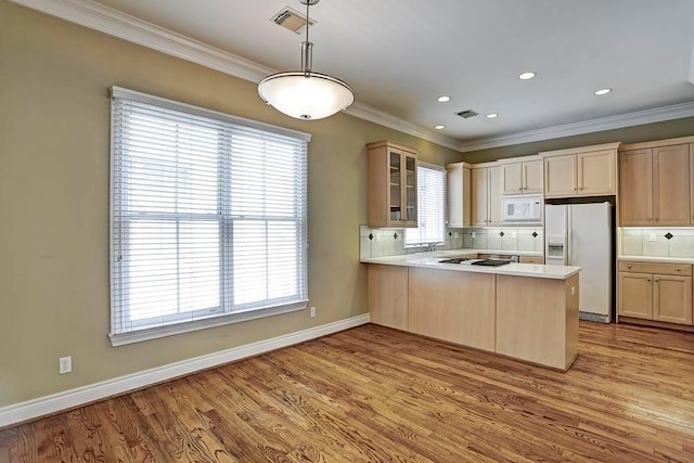 kitchen featuring backsplash, white appliances, light wood-type flooring, and kitchen peninsula