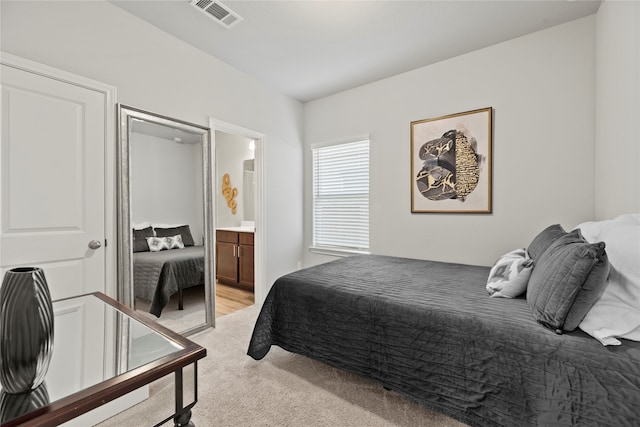 carpeted bedroom featuring ensuite bath