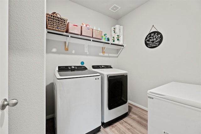 washroom featuring washing machine and dryer and light wood-type flooring