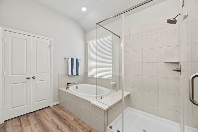 bathroom with shower with separate bathtub, wood-type flooring, and vaulted ceiling