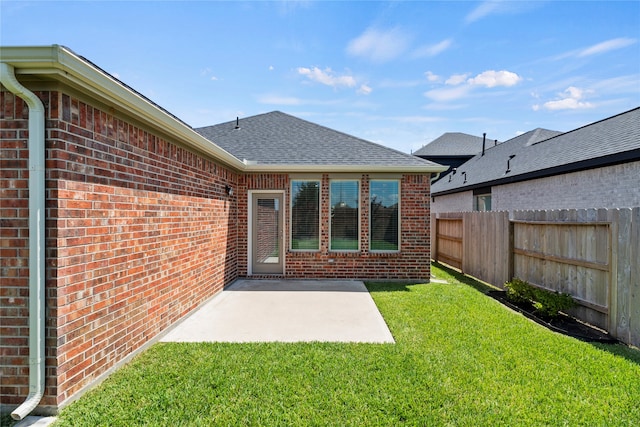 rear view of house with a yard and a patio area