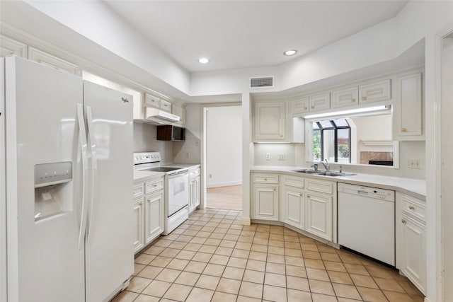 kitchen with sink, white appliances, light tile patterned floors, and white cabinets