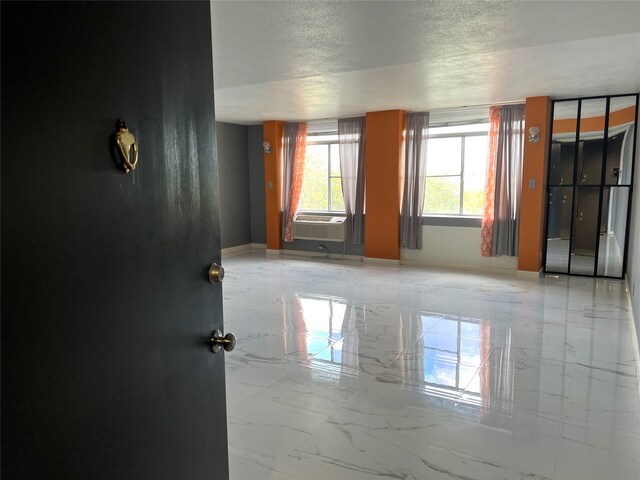 empty room with tile patterned flooring, cooling unit, and a textured ceiling