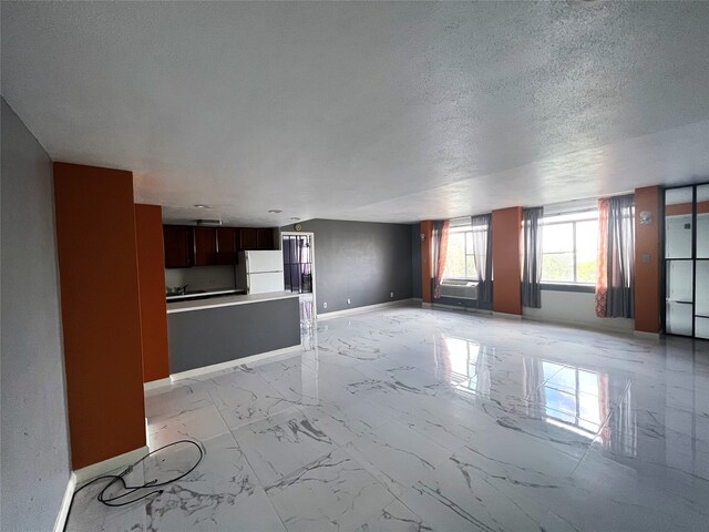 unfurnished living room featuring a textured ceiling and light tile patterned floors