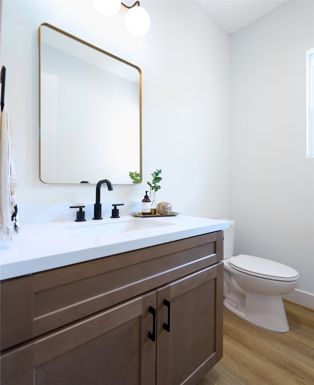 bathroom with vanity, hardwood / wood-style floors, and toilet