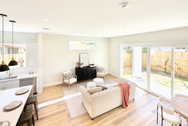 living room with sink and light hardwood / wood-style flooring