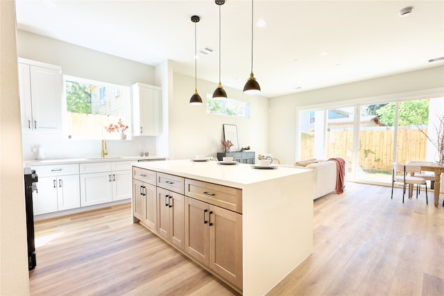 kitchen featuring light hardwood / wood-style flooring, white cabinets, hanging light fixtures, and a kitchen island