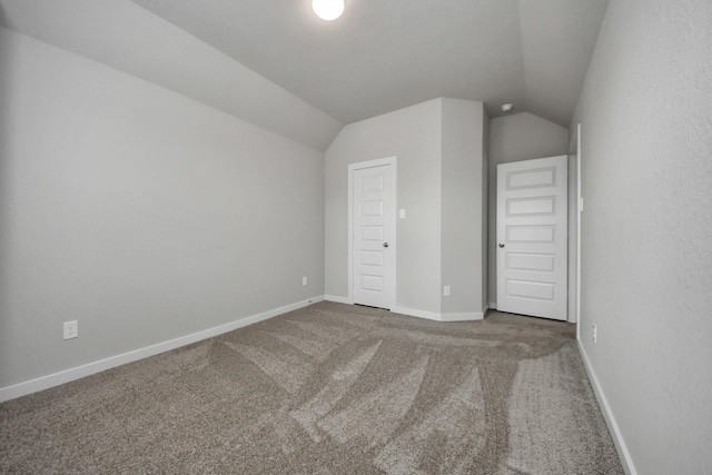 unfurnished bedroom featuring carpet floors and vaulted ceiling