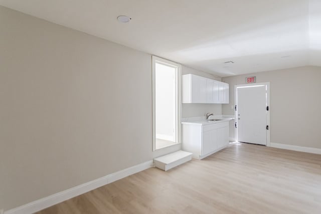 unfurnished living room featuring sink and light wood-type flooring