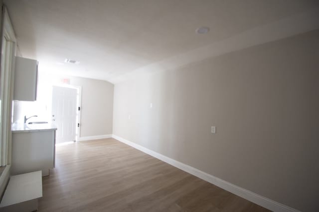 unfurnished living room with hardwood / wood-style flooring and sink