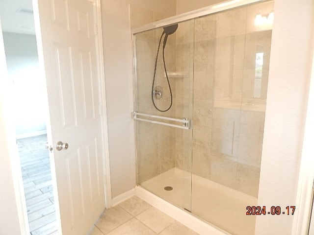 bathroom with tile patterned flooring and an enclosed shower