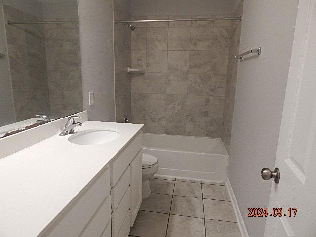 full bathroom with tiled shower / bath combo, vanity, toilet, and tile patterned floors