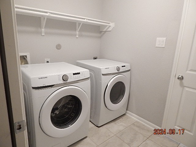 laundry area with light tile patterned floors and independent washer and dryer