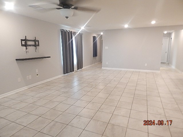 unfurnished room with ceiling fan and light tile patterned floors