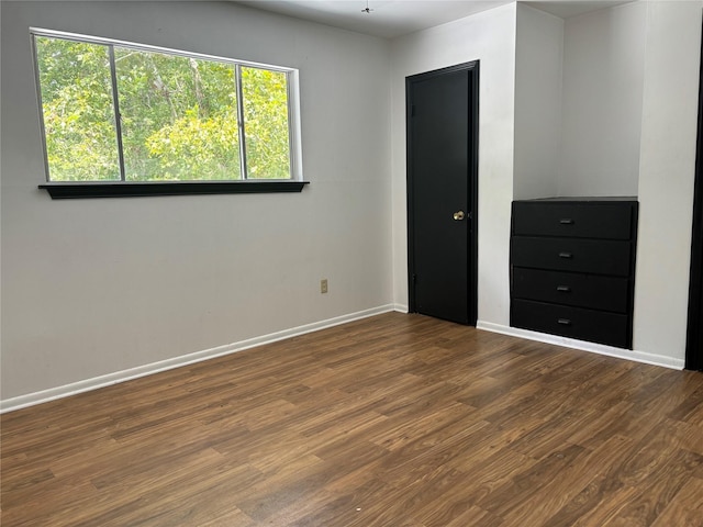 unfurnished bedroom featuring dark hardwood / wood-style flooring