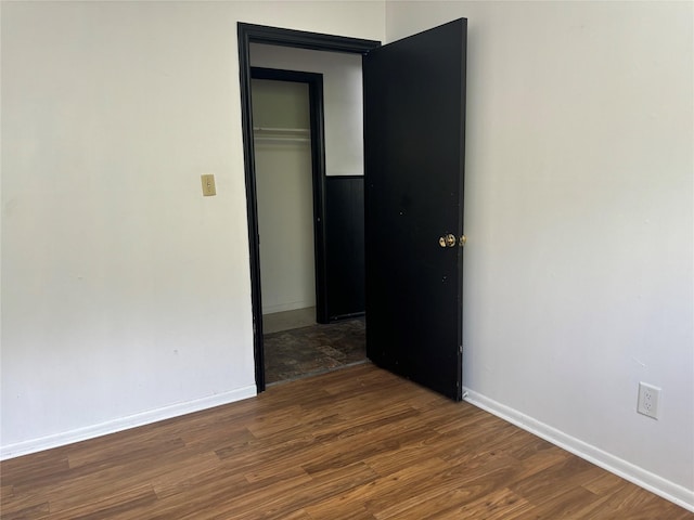 unfurnished room with dark wood-type flooring