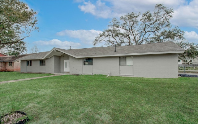 rear view of house featuring a yard