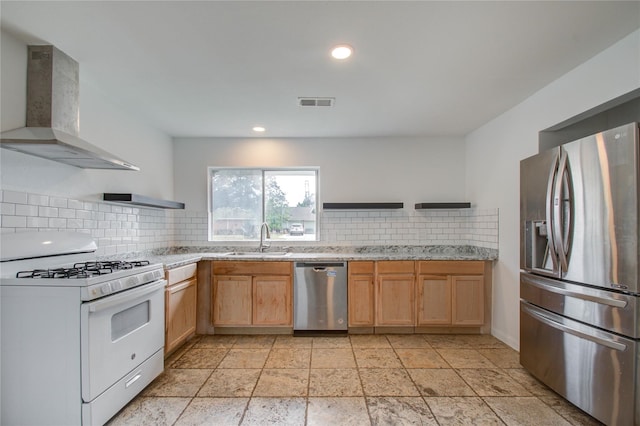 kitchen with sink, tasteful backsplash, wall chimney exhaust hood, appliances with stainless steel finishes, and light brown cabinetry