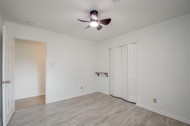 unfurnished bedroom featuring a closet, light wood-type flooring, and ceiling fan