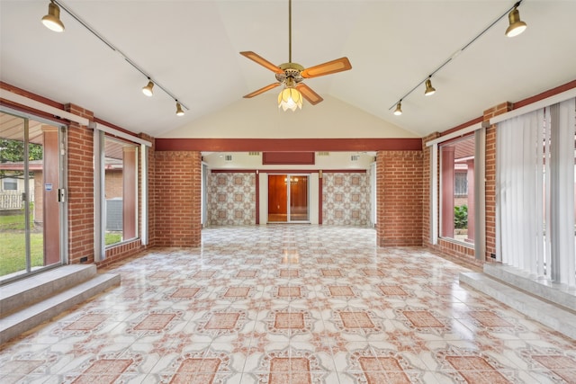 unfurnished sunroom featuring rail lighting, lofted ceiling, and ceiling fan