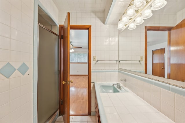 bathroom featuring vanity, tile patterned floors, tile walls, and an enclosed shower