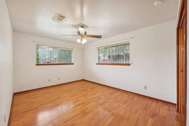 empty room featuring ceiling fan, a textured ceiling, and light wood-type flooring