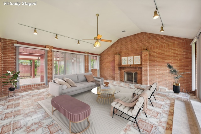 living room with a wealth of natural light, brick wall, and track lighting