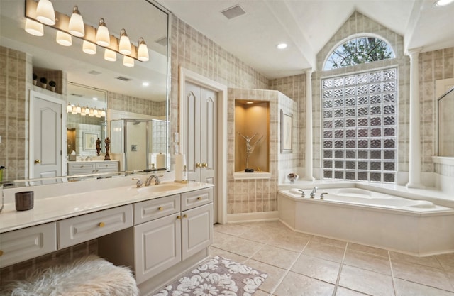 bathroom featuring vanity, independent shower and bath, lofted ceiling, and tile patterned flooring